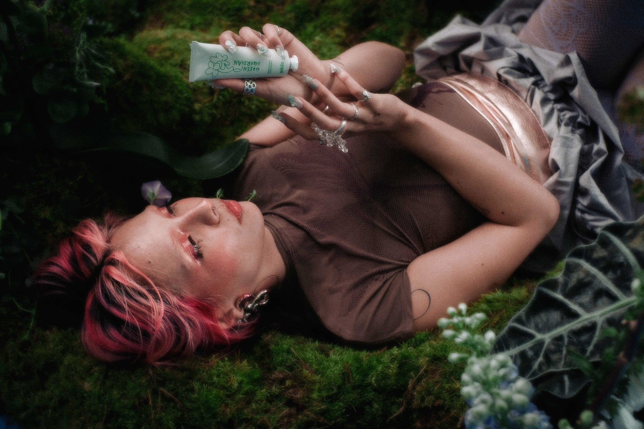 Model holding Green Guardian Barrier Repair Moisturiser Cream surrounded by nature