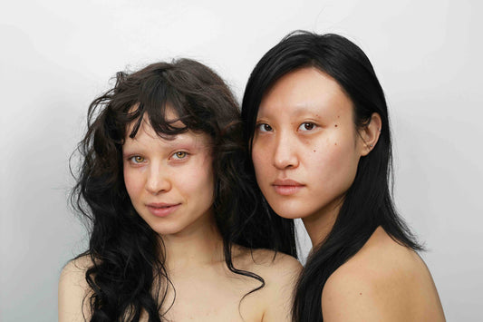 two women with different skin tones bare-faced looking directly at camera for quinta unfiltered skincare campaign