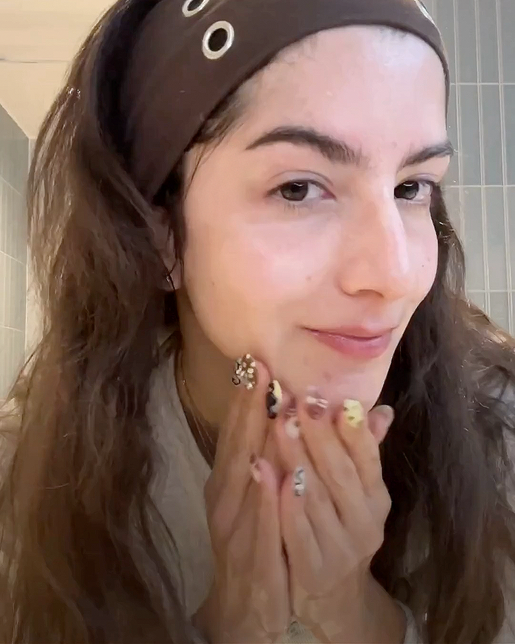 Woman washing her face in a bathroom setting