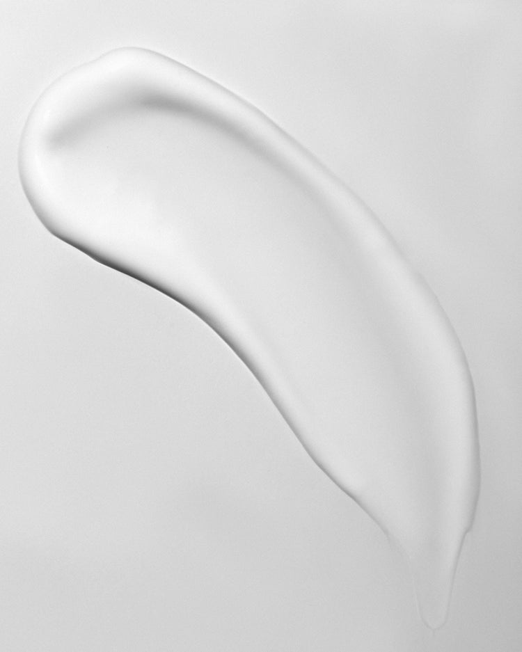 White cream or lotion smear on a light gray background