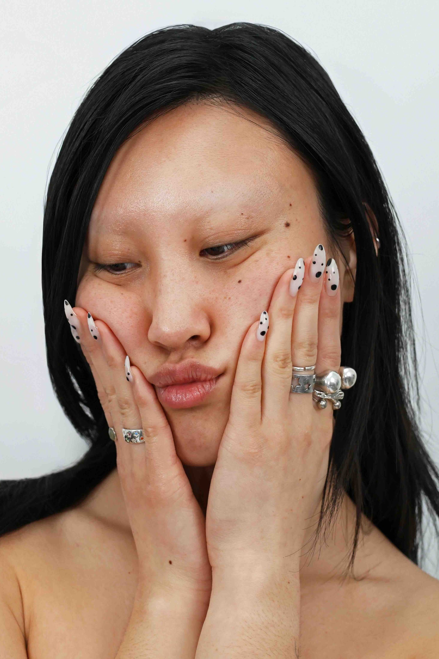 model with nail art holding face bare-skinned for quinta real skin skincare campaign